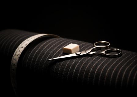 Dettaglio di tessuti e strumenti del sarto presso Olympus Tailors